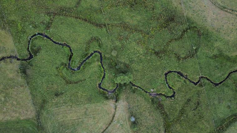 Rivière sinueuse à travers la campagne, vue du ciel par drone