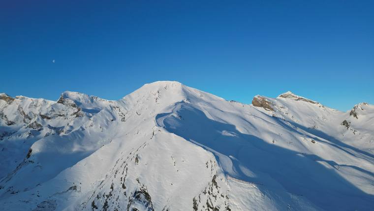 Sommets enneigés sous un ciel bleu, vue aérienne par drone