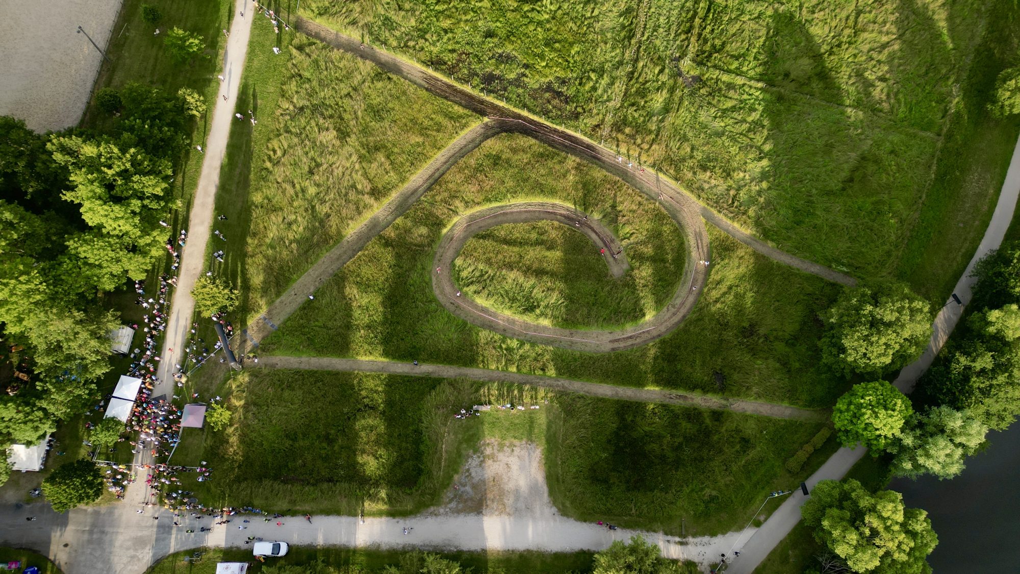 Parcours sinueux tracé dans l'herbe d'un parc, vu à la verticale par drone