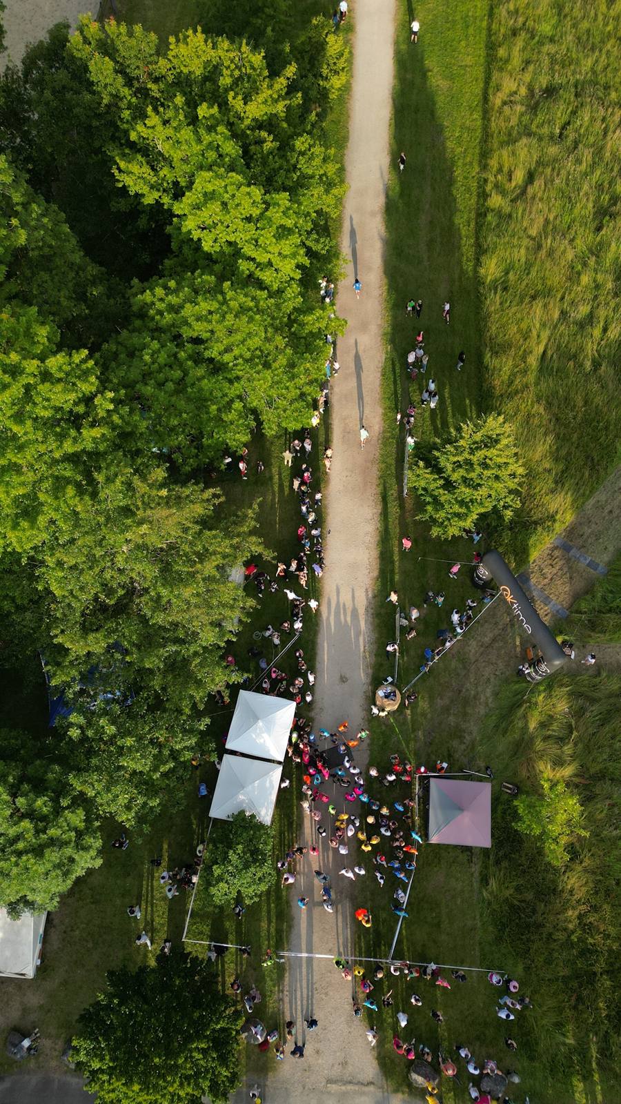 Coureurs sur un chemin arboré pendant une course, vue du ciel par drone