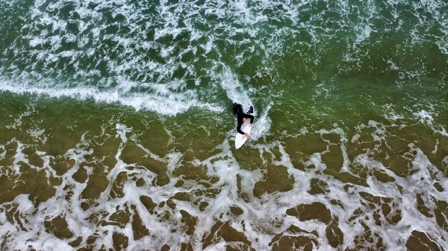 Surfeur dans l'écume, vue du dessus par drone